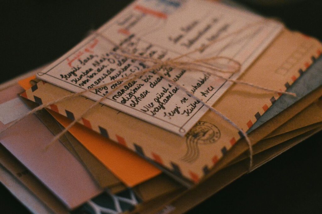 Tłumaczenie, transkreacja, lokalizacja – co to znaczy A bundle of vintage letters tied with twine on a dark background, evoking nostalgia.