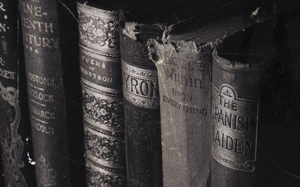 pexels photo 3765180 Close-up of vintage hardcover books with decorative spines in grayscale.