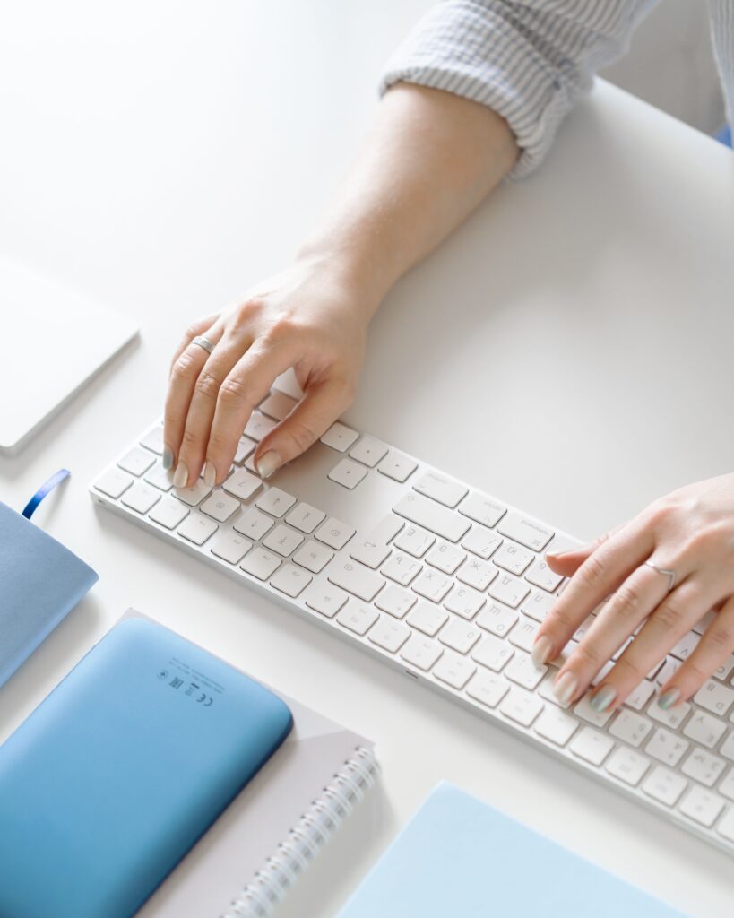 pexels photo 8572604 8572604 Close-up of hands typing on a keyboard in a well-organized office space, showcasing a modern work environment.